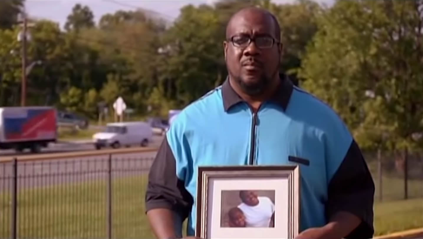 John Howard holding a photo of his missing boys